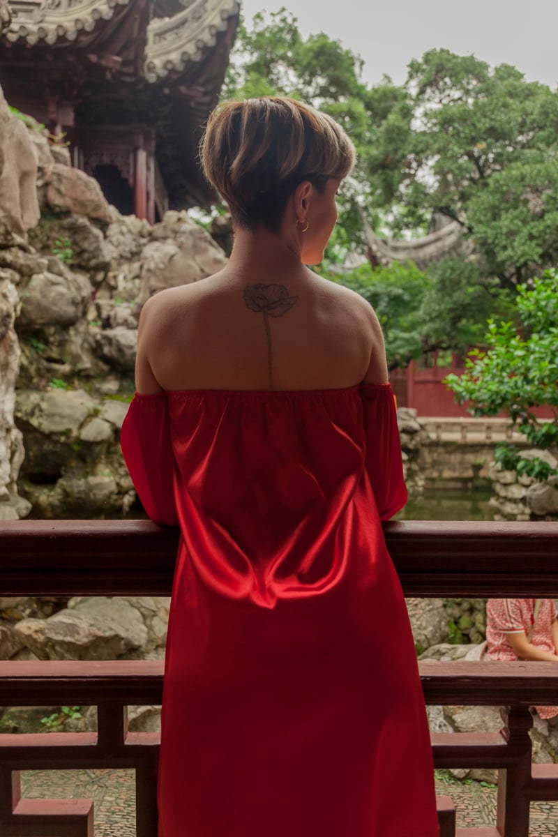 Beautiful young woman in red dress in Yuyuan Garden, Shanghai, China